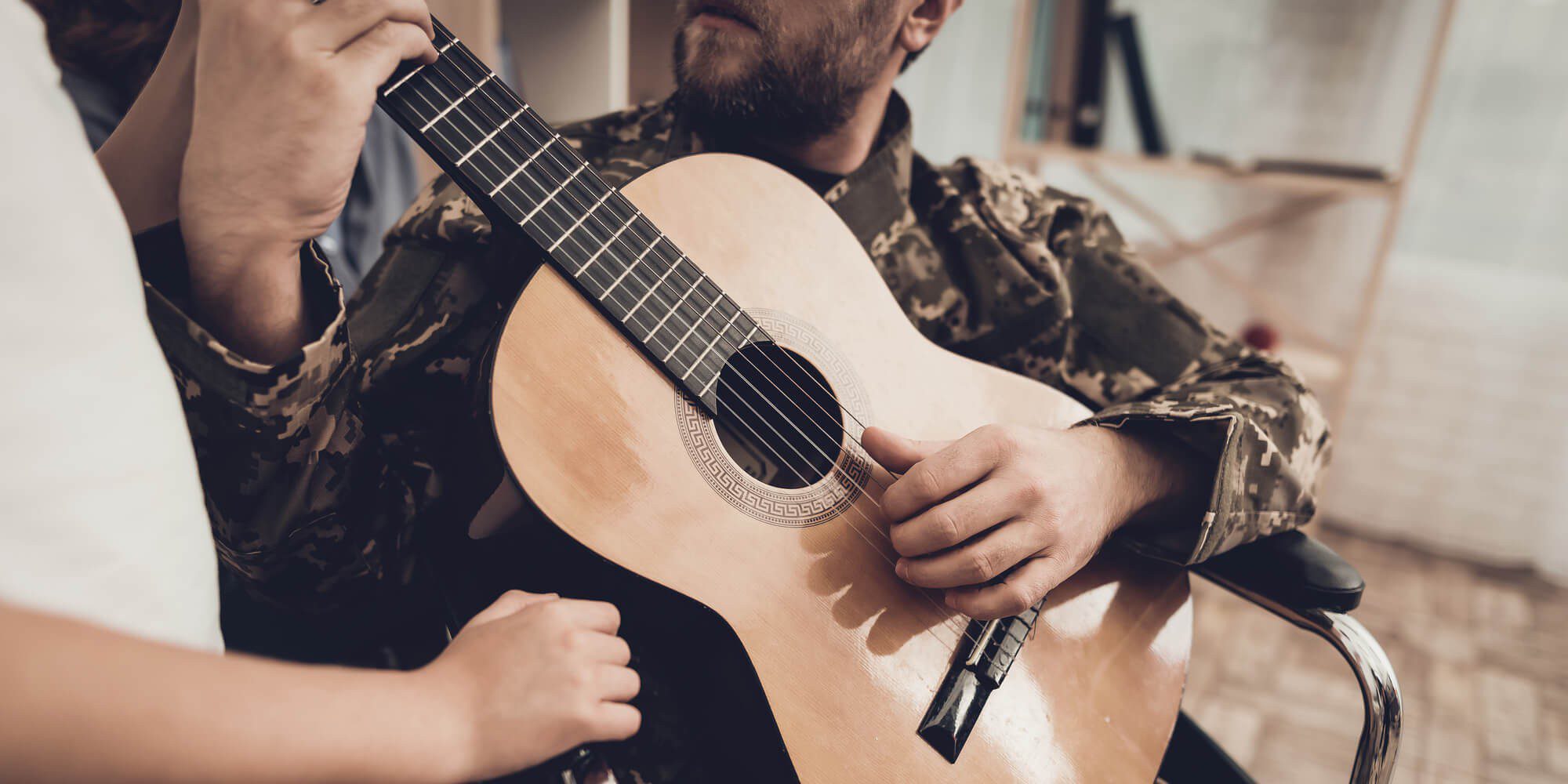 man in uniform playing the guitar at Veteran Alcohol Rehab