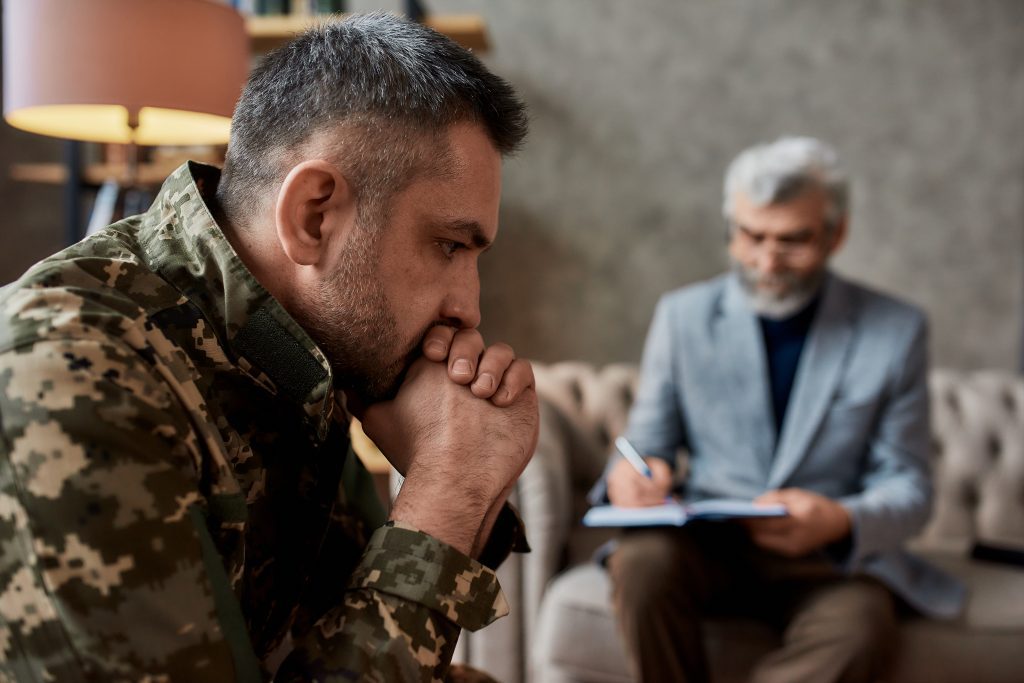 A veteran working through trauma while talking to a psychotherapist about PTSD vs CPTSD